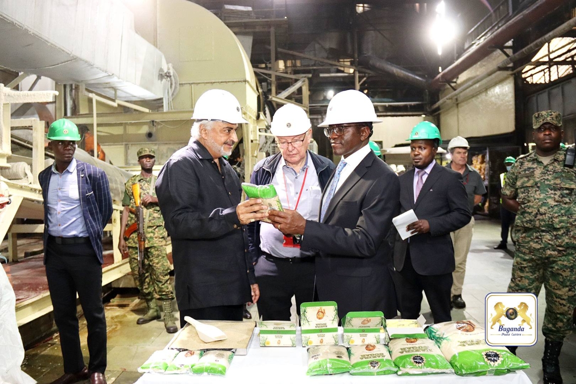 The Managing Director of Madhvani Group showing the Katikkiro the sugar produced by the company The Managing Director of Madhvani Group showing the Katikkiro the sugar produced by the company